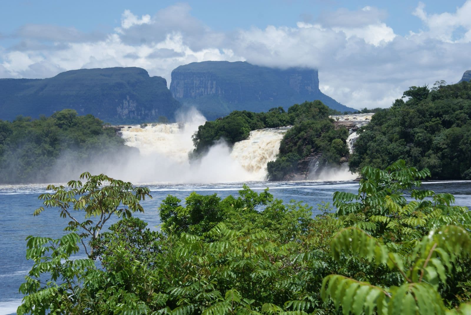 Waterfalls pouring into the Canaima lagoon, with tepuis in the background