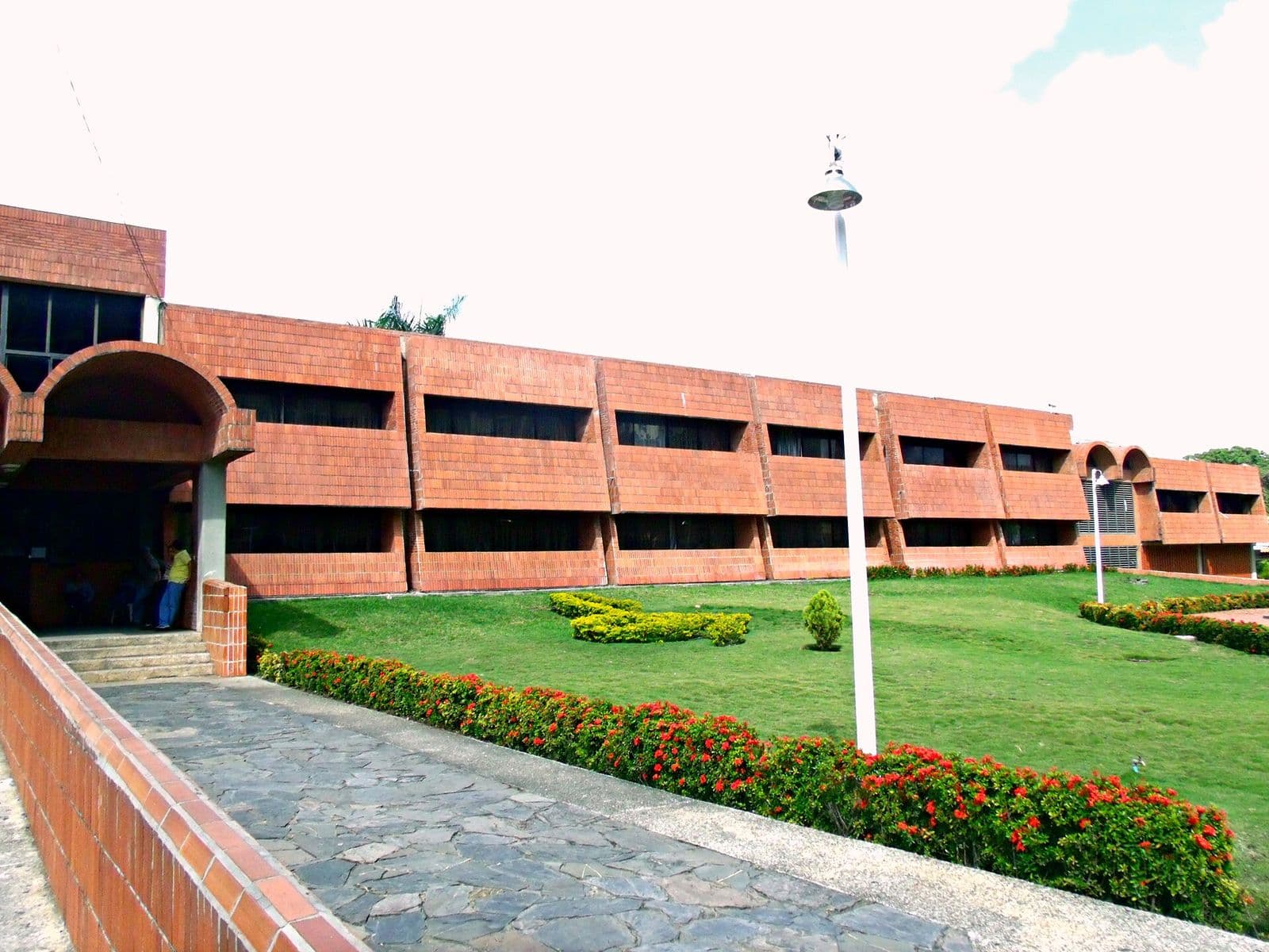 Brick building of the Conservatorio Vicente Emilio Sojo, with a garden and a stone path