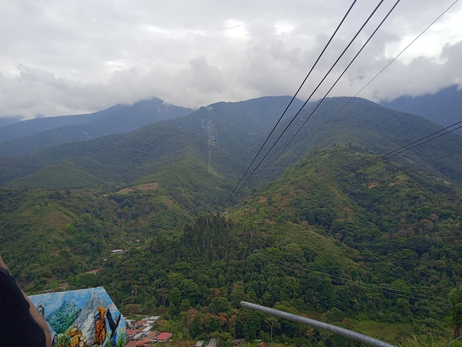 Cables of the Mukumbarí cable car over forested mountains in the Sierra Nevada de Mérida