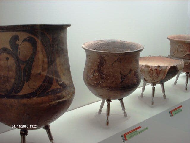 Pre-Hispanic clay vessels with legs and painted decoration in a display case at the Quíbor museum